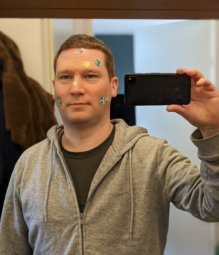 Martin in de spiegel, gezicht versierd met stickers